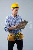Male architect looking at clipboard