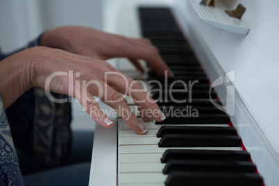 Mid section woman playing piano