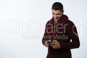 Man in winter cloth using mobile phone against white background