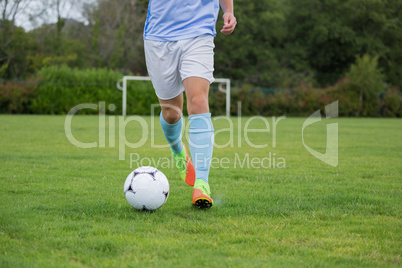 Football player dribbling the soccer