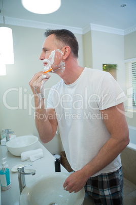Man shaving his beard with razor