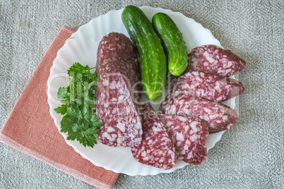 Slices of sausage and cucumber on the plate.