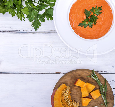 pumpkin soup in a white plate and ingredients