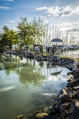 Sailing boats at pier of lake.