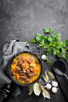 Meat stew, goulash in a cast iron pot, top view