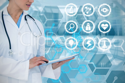 Composite image of happy doctor using her tablet pc