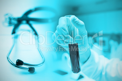 Composite image of scientist holding a test tube