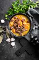 Meat stew, goulash in a cast iron pot, top view