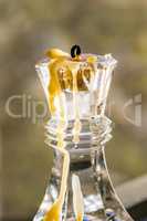 Glass candle holder with burnt low candle, closeup.
