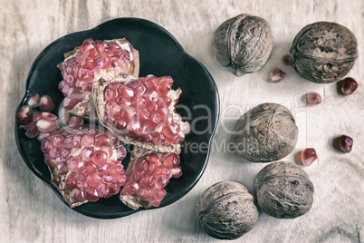 Pomegranate fruits on the plate and walnuts.