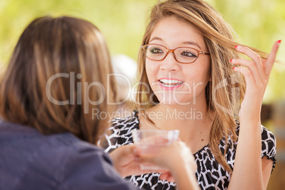 Two Mixed Race Girlfriends Talking Over Drinks Outdoors