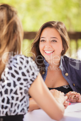 Two Mixed Race Girlfriends Having A Conversation At An Outoor Pa