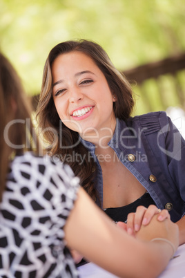 Two Mixed Race Girlfriends Having A Conversation At An Outoor Pa