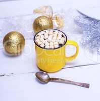 hot chocolate with marshmallows in a yellow cup and Christmas to
