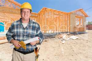 Male Contractor With House Plans Wearing Hard Hat In Front of Ne