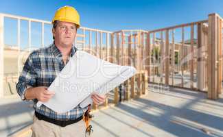 Male Contractor With House Plans Wearing Hard Hat Inside New Hou