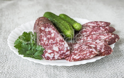 Slices of sausage and cucumber on the plate.