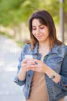 Beautiful Young Ethnic Woman Using Her Smartphone Outside.