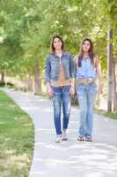 Two Beautiful Ethnic Twin Sisters Walking Outdoors.