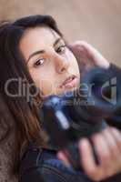 Young Adult Ethnic Female Photographer Against Wall Holding Came