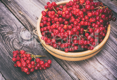 bunch of red viburnum in a wooden bowl