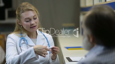 Attractive female doctor with thermometer at clinic