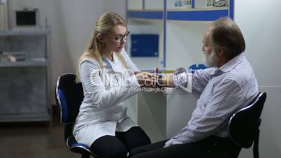 Physician checking male patient's blood pressure