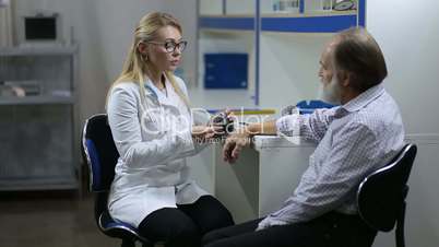 Cardiologist measuring patient's blood pressure