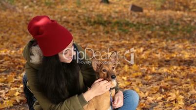 Portrait of girl with lovely dog in yellow foliage