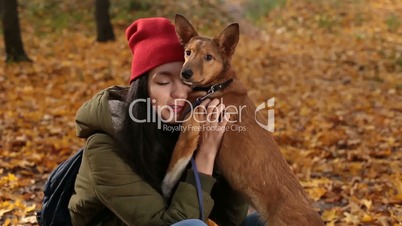 Hipster girl playing with her dog on autumn day