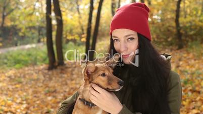 Portrait of smiling woman with her dog in autumn