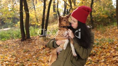 Tender scene of woman with dog in autumn park