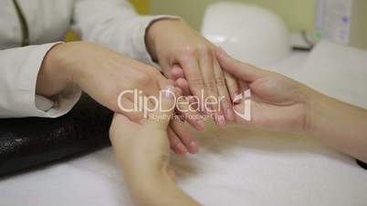 Professional manicurist examining female hands