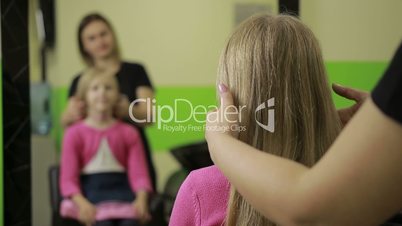 Female hairdresser arranging hairdo in barber shop