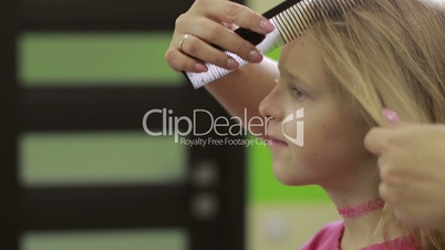 Hairdresser combing client's hair with comb