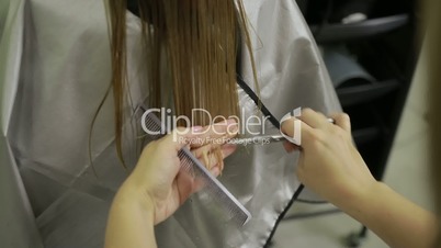 Hairdresser shortening hair tips with scissors