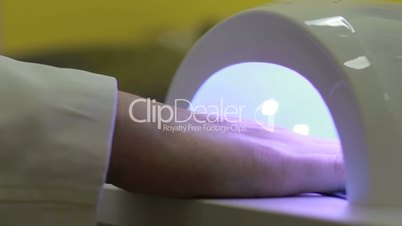 UV lamp gel polish manicure in beauty salon