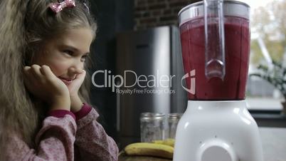 Cute girl blending fresh berry smoothie in blender