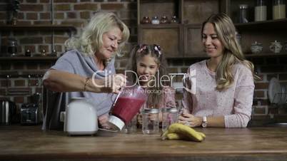 Grandmother pouring berry smoothie into mason jars