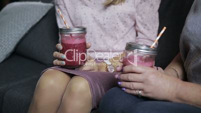 Mason jars of fresh smoothies in females hands