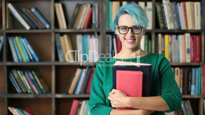 Smiling female student holding books and smiling