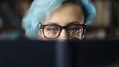 Closeup of young woman's face behind book cover