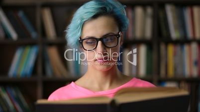 Portrait of hipster woman reading book in library