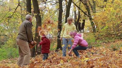 Grandparents and kids having fun in autumn park