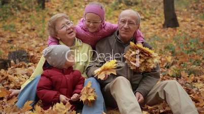 Multi generation family relaxing in autumn park