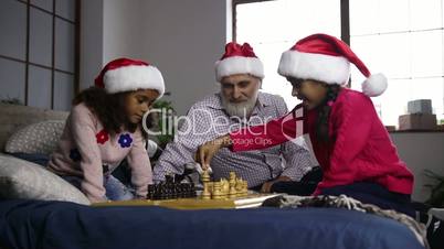 Two mixed race sisters playing chess on xmas eve