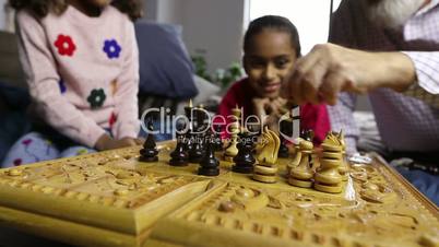 Diverse family playing chess together at home