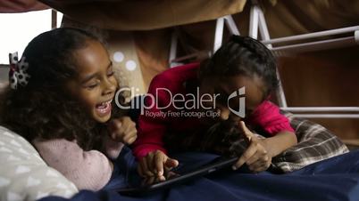 Excited girls watching funny video on tablet