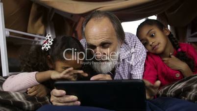 Kids teaching grandpa to use smart gadget
