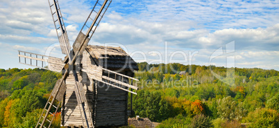old wooden windmill in field and sky